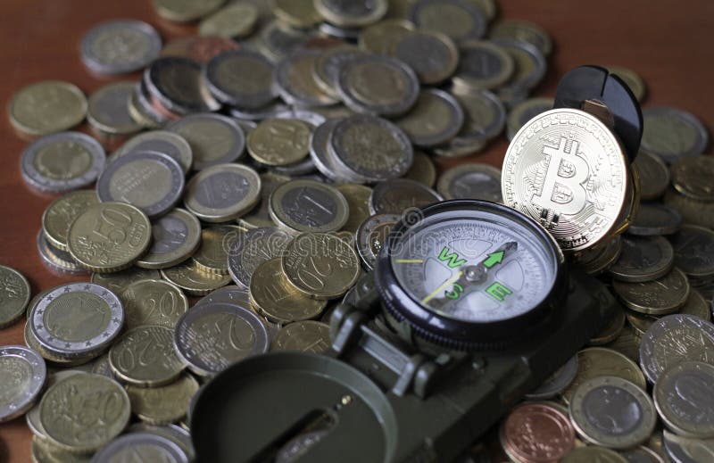 Bitone su una bussola situata su una pila di monete in euro fotografie stock