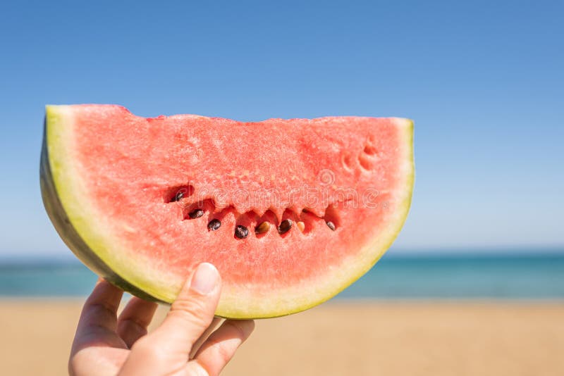 Bitten Ripe Piece of Watermelon in Woman Hands on the Beach in a Hot ...