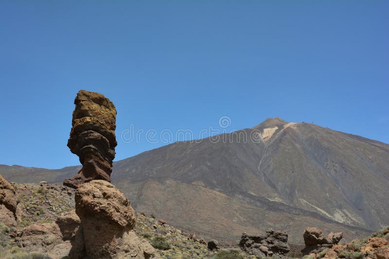 The bizarrely shaped Roque Cinchado rock of volcanic rock in Teide National Park on the Canary Island of Tenerife, Spain. With views of Mount Teide and blue skies. The bizarrely shaped Roque Cinchado rock of volcanic rock in Teide National Park on the Canary Island of Tenerife, Spain. With views of Mount Teide and blue skies