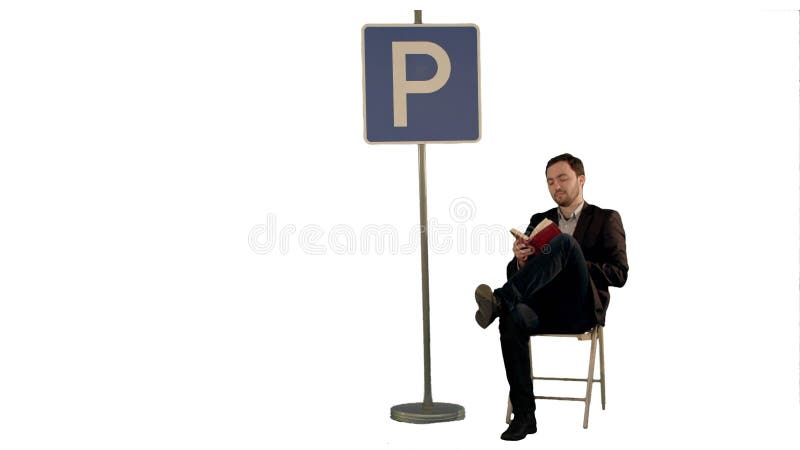 Biznesmen czyta książkowego pobliskiego parking znaka na białym tle odizolowywającym fotografia stock Biznesmen czyta książkowego pobliskiego parking znaka na białym tle odizolowywającym fotografia stock