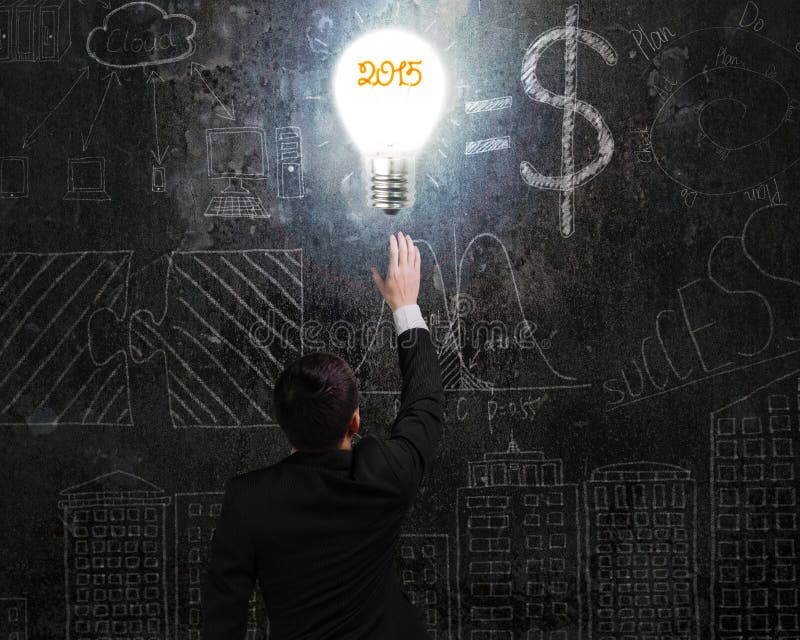 Biznesmen dotyka 2015 żarówka iluminującego zmrok doodles wa zdjęcie stock Biznesmen dotyka 2015 żarówka iluminującego zmrok doodles wa zdjęcie stock