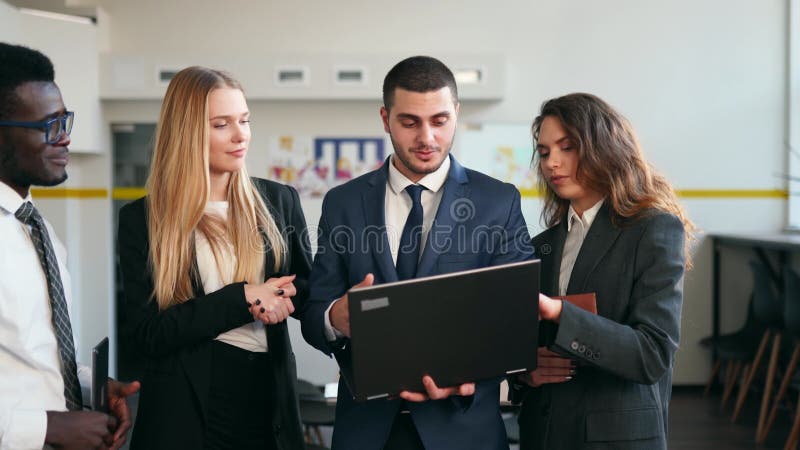 Biznesmen pokazuje dane na temat laptopa. międzynarodowi partnerzy biznesowi omawiają wyniki projektu na spotkaniu w