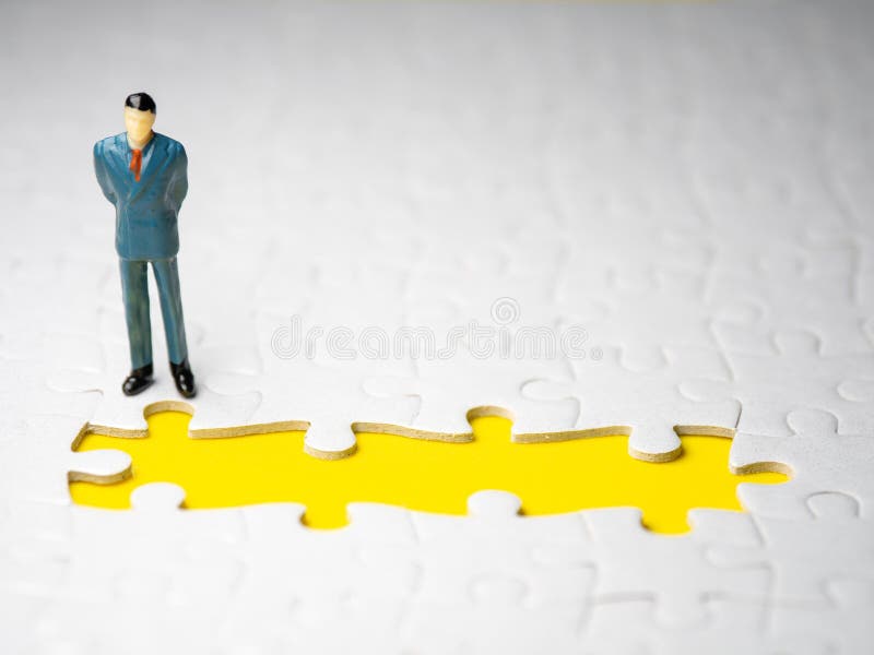Biznesmen pozycja przed chybianie kawałka wyrzynarką na żółtym tle zdjęcia stock Biznesmen pozycja przed chybianie kawałka wyrzynarką na żółtym tle zdjęcia stock