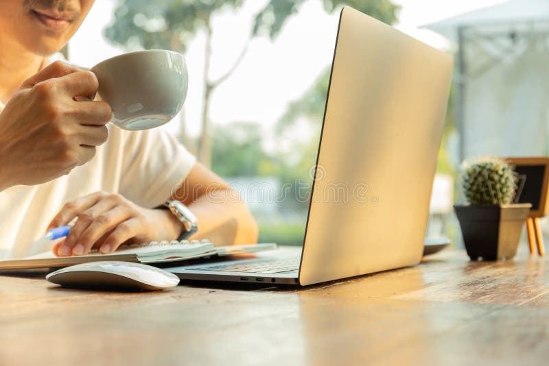 Biznesmen praca na biurkach wręcza trzymać filiżankę coffeewith laptop na stole obrazy royalty free Biznesmen praca na biurkach wręcza trzymać filiżankę coffeewith laptop na stole obrazy royalty free