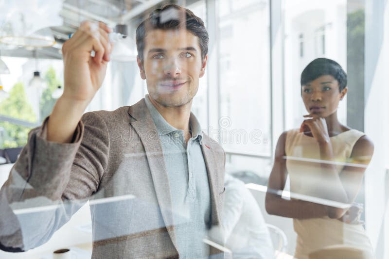 Biznesmen pracuje z bizneswomanem i pisze na przejrzystej desce zdjęcia royalty free Biznesmen pracuje z bizneswomanem i pisze na przejrzystej desce zdjęcia royalty free