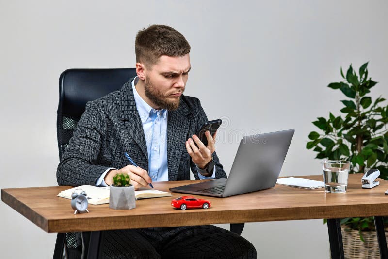 Biznesmen siedzący na krześle przy biurku i rozmawiający przez telefon zdjęcie royalty free