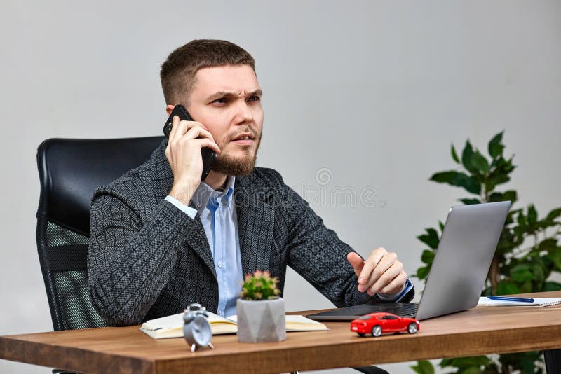 Biznesmen siedzący na krześle przy biurku i rozmawiający przez telefon fotografia royalty free