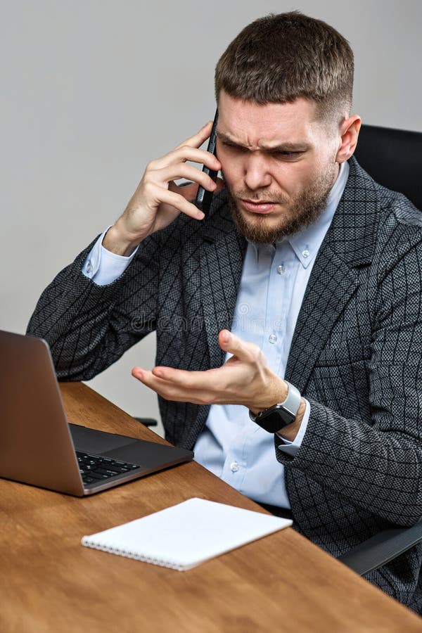 Biznesmen siedzący na krześle przy biurku i rozmawiający przez telefon fotografia stock