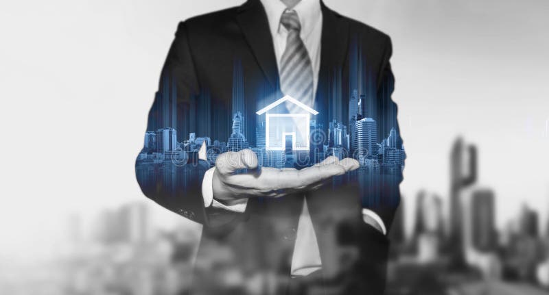 Biznesmen trzyma nowożytnego budynku hologram i domowa ikona, Nieruchomość biznes, budynek technologia i mądrze domowy pojęcie