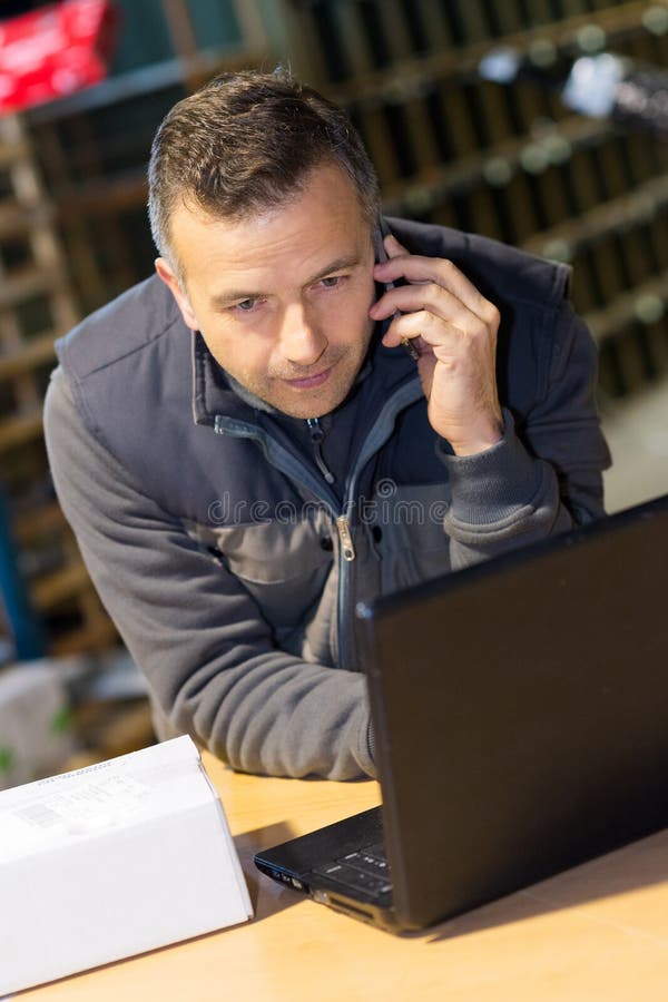 Biznesmen u?ywa laptop w magazynie obrazy stock Biznesmen u?ywa laptop w magazynie obrazy stock