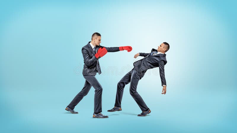 Biznesmen w bokserskich rękawiczkach nie udać się uderzać pięścią innego mężczyzna który kieruje unikać kopnięcie obraz royalty free Biznesmen w bokserskich rękawiczkach nie udać się uderzać pięścią innego mężczyzna który kieruje unikać kopnięcie obraz royalty free