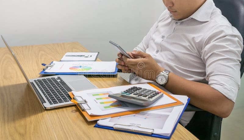 Biznesmen wiadomość tekstowa na telefonie komórkowym przy miejsce pracy obrazy stock Biznesmen wiadomość tekstowa na telefonie komórkowym przy miejsce pracy obrazy stock