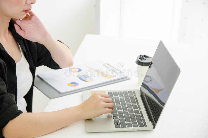 Biznesowa kobieta pracuje na laptopie z kawą i dokumentem w domu obrazy stock Biznesowa kobieta pracuje na laptopie z kawą i dokumentem w domu obrazy stock