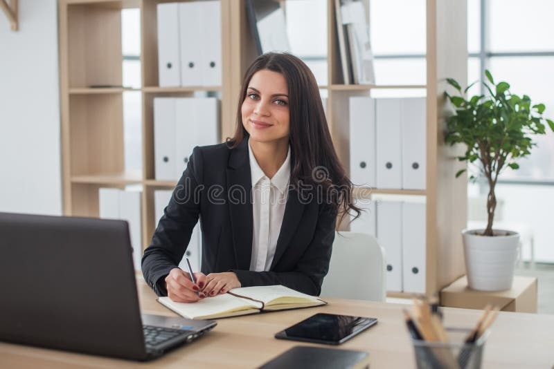 Biznesowa kobieta z notatnikiem w biurze, miejsce pracy zdjęcia royalty free Biznesowa kobieta z notatnikiem w biurze, miejsce pracy zdjęcia royalty free
