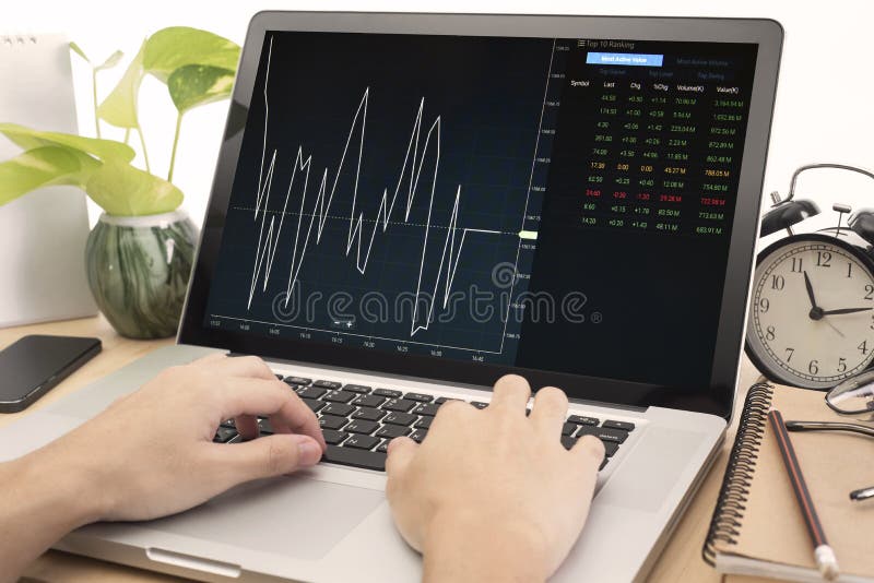 Biznesowa ręka pracuje na komputerowym notatniku z Finansowym handlem obraz stock Biznesowa ręka pracuje na komputerowym notatniku z Finansowym handlem obraz stock