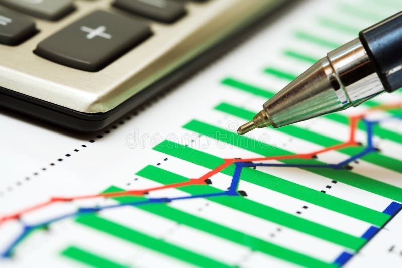 Calculator, pen and stock market graphs analysis. Calculator, pen and stock market graphs analysis