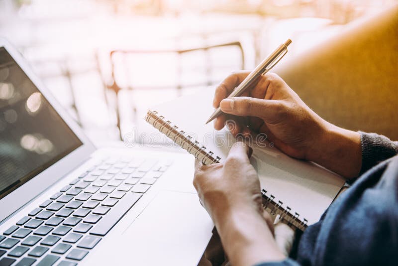 Biznesowy mężczyzna pracuje na laptopie i pisze notatniku obraz stock Biznesowy mężczyzna pracuje na laptopie i pisze notatniku obraz stock