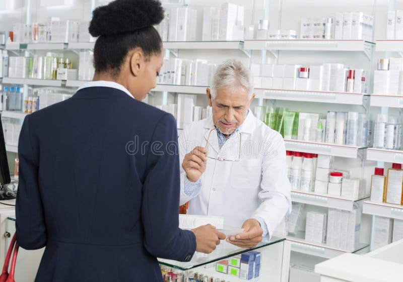 Bizneswoman Pokazuje receptę chemik W aptece fotografia stock Bizneswoman Pokazuje receptę chemik W aptece fotografia stock