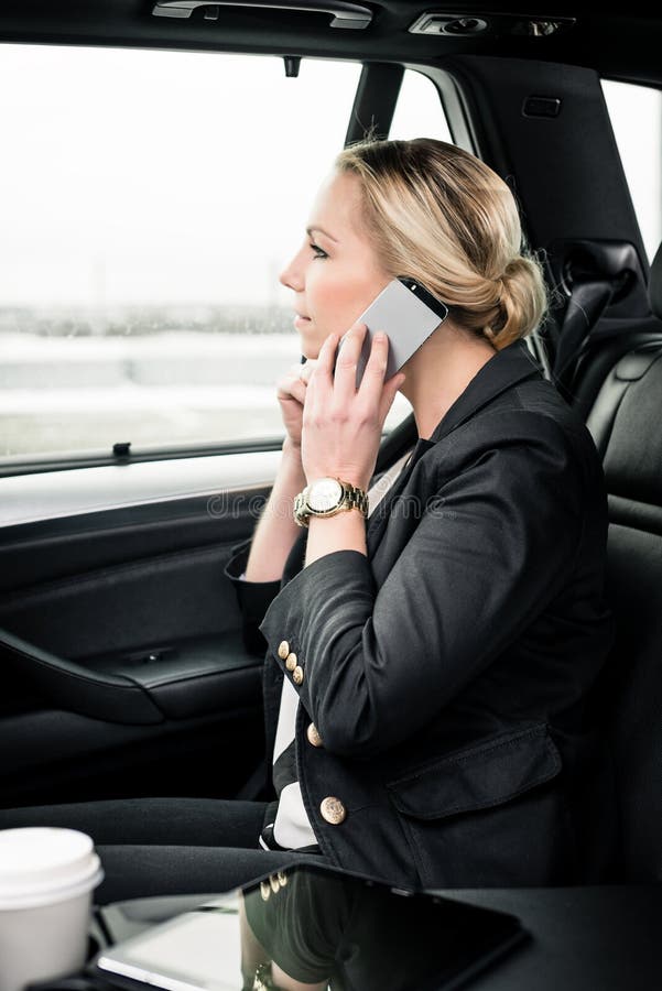 Bizneswoman u?ywa smartphone w samochodzie zdjęcia stock Bizneswoman u?ywa smartphone w samochodzie zdjęcia stock
