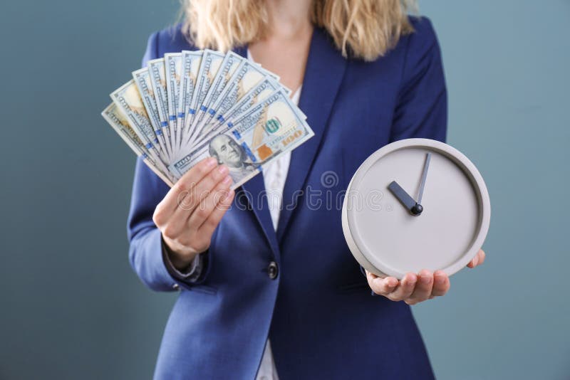 Bizneswomanu mienia pieniądze na koloru tle i zegar Czasu zarządzanie obraz royalty free Bizneswomanu mienia pieniądze na koloru tle i zegar Czasu zarządzanie obraz royalty free