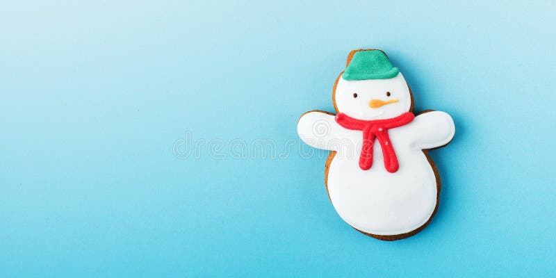 Funny snowman of delicious traditional gingerbread on blue gradient background view from above Christmas banner with template. Funny snowman of delicious traditional gingerbread on blue gradient background view from above Christmas banner with template