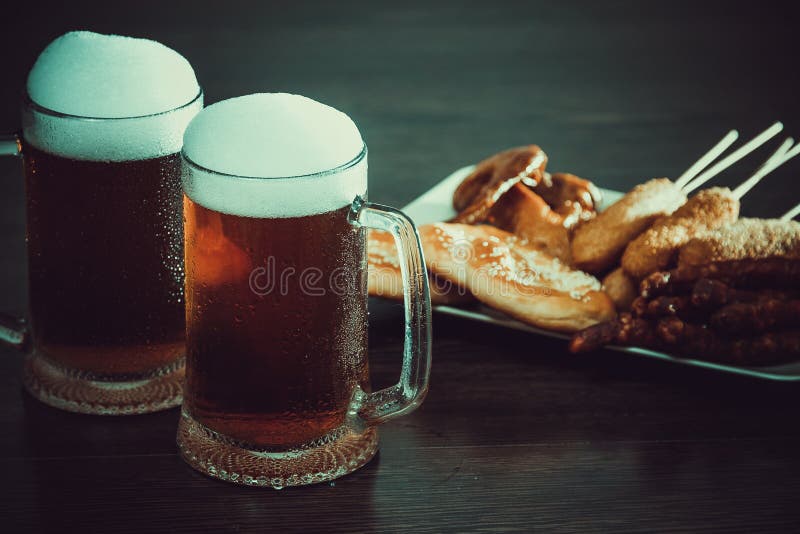 Bière allemande traditionnelle d'Oktoberfest de nourriture, ailes de poulet cuites au four, maïs éclaté, assortiment des bretzels image libre de droits Bière allemande traditionnelle d'Oktoberfest de nourriture, ailes de poulet cuites au four, maïs éclaté, assortiment des bretzels image libre de droits