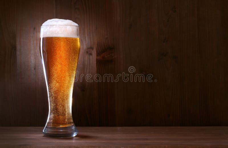 Bière en verre sur le fond en bois