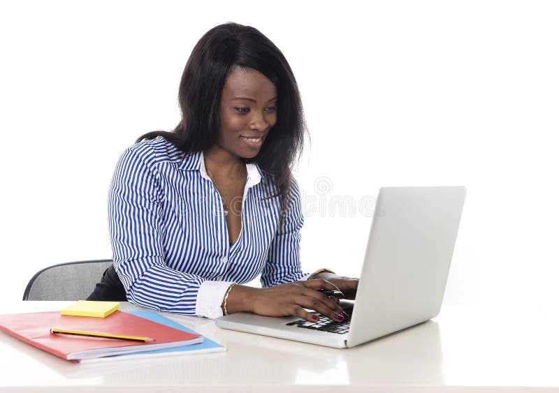 Black african american ethnicity woman working at computer laptop at office desk smiling happy stock photos