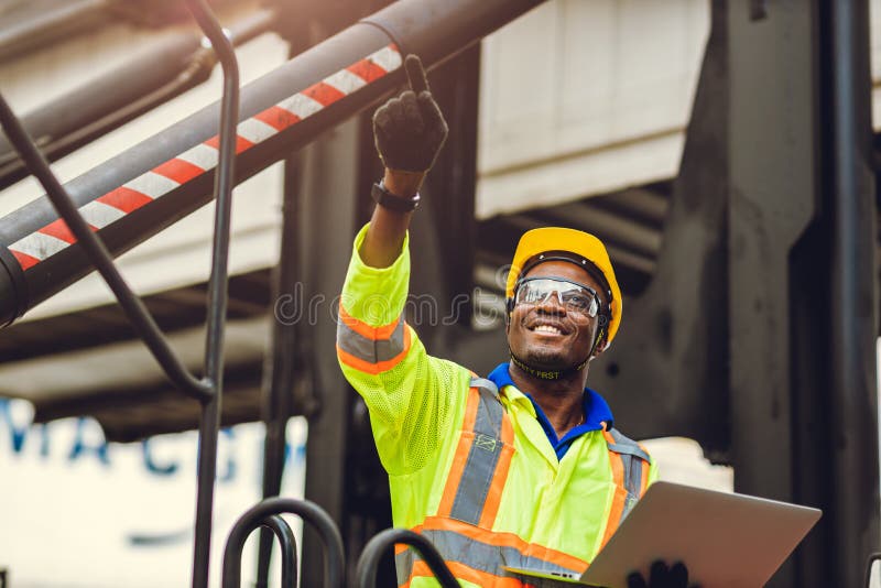 Black African American worker as staff foreman proud to happy smile working control loading cargo in shipping logistic warehouse