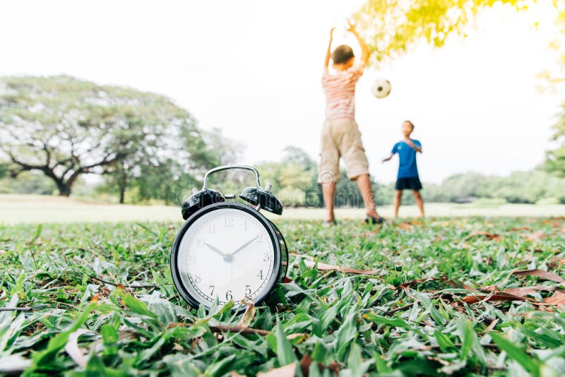 Black alarm clock and boy play in the park