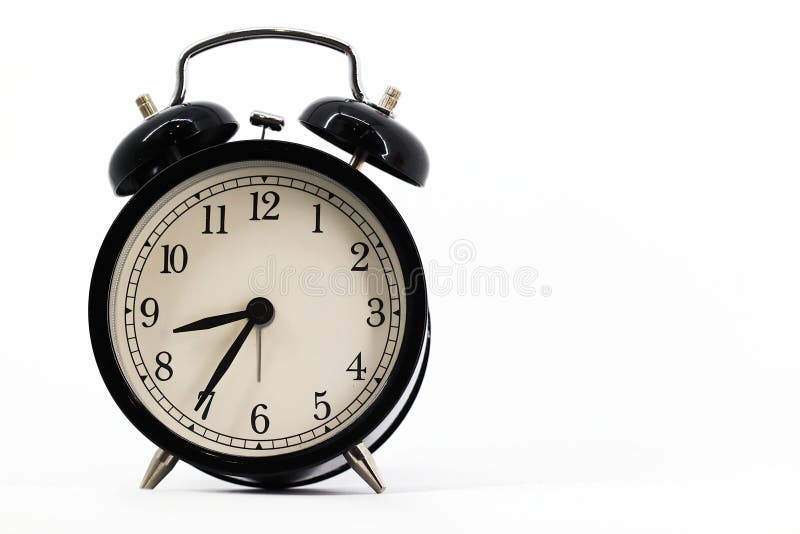 A black alarm clock with two bells on top, chrome handle, and legs, set against a white background. Timeless design meets royalty free stock photos