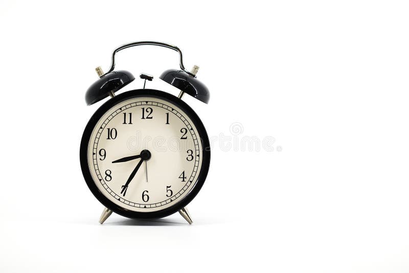 A black alarm clock with two bells on top, chrome handle, and legs, set against a white background. Timeless design meets royalty free stock image