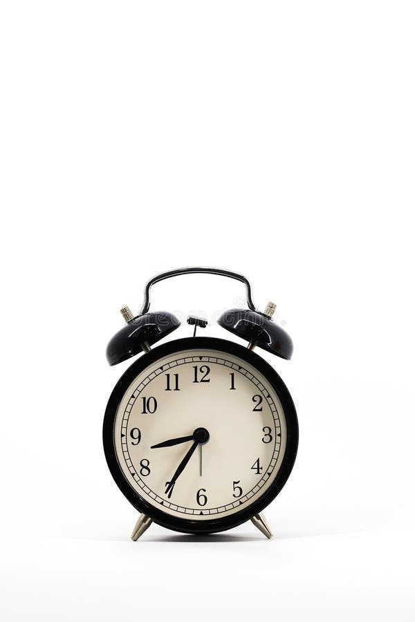 A black alarm clock with two bells on top, chrome handle, and legs, set against a white background. Timeless design meets stock photography