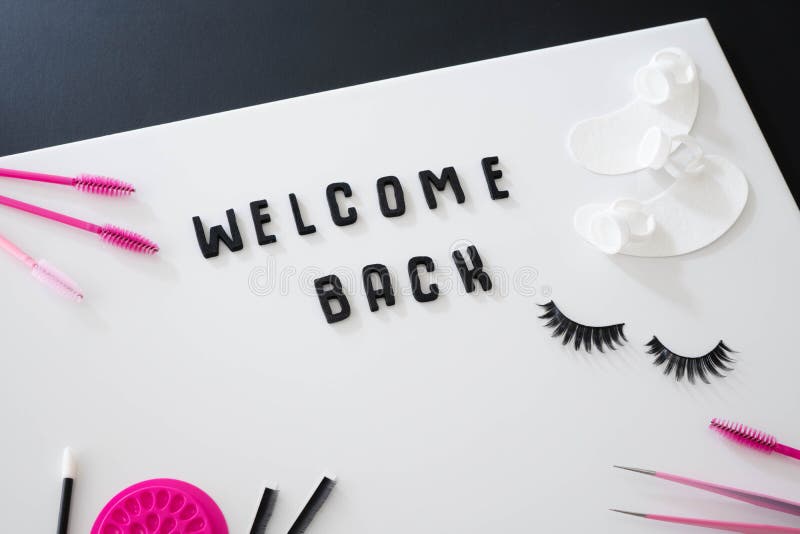 Welcome Back beauty business sign. Black background with pink and black beauty salon treatment products around the frame. Welcome back concept with black royalty free stock photos Welcome Back beauty business sign. Black background with pink and black beauty salon treatment products around the frame. Welcome back concept with black royalty free stock photos