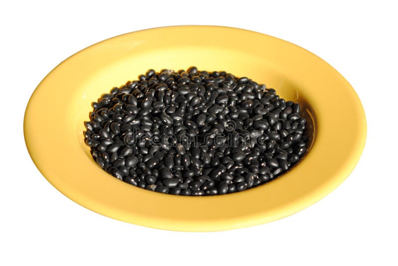 Black beans in a yellow dish isolated