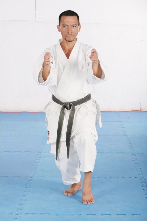 Black Belt Karate Man Jumping To Give a High Kick Stock Photo Image