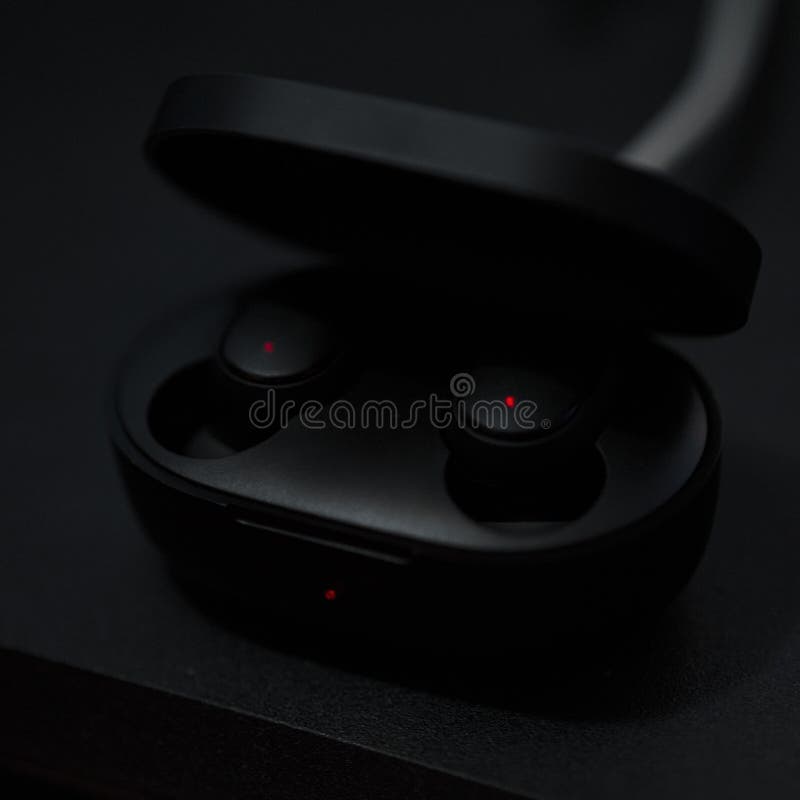 Black Bluetooth Headphones are Charging in the Case. Stock Image