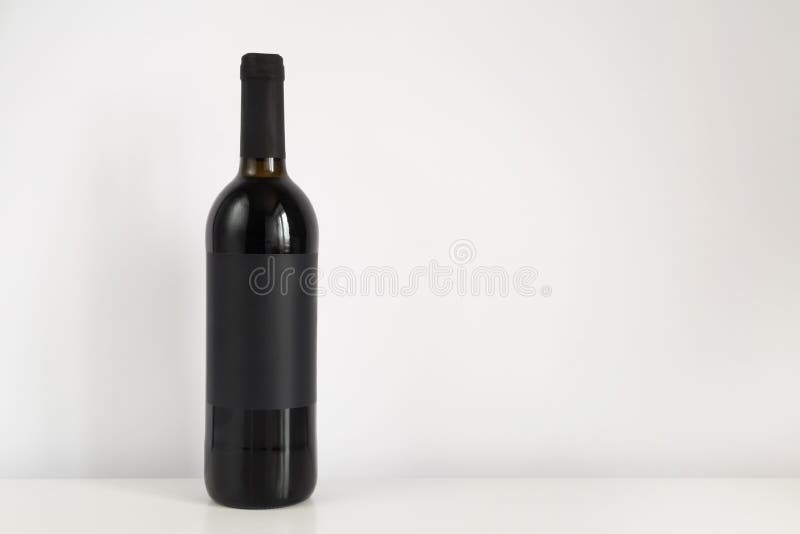 Black Bottle of Red Wine on a White Background with Copy Space. Wine