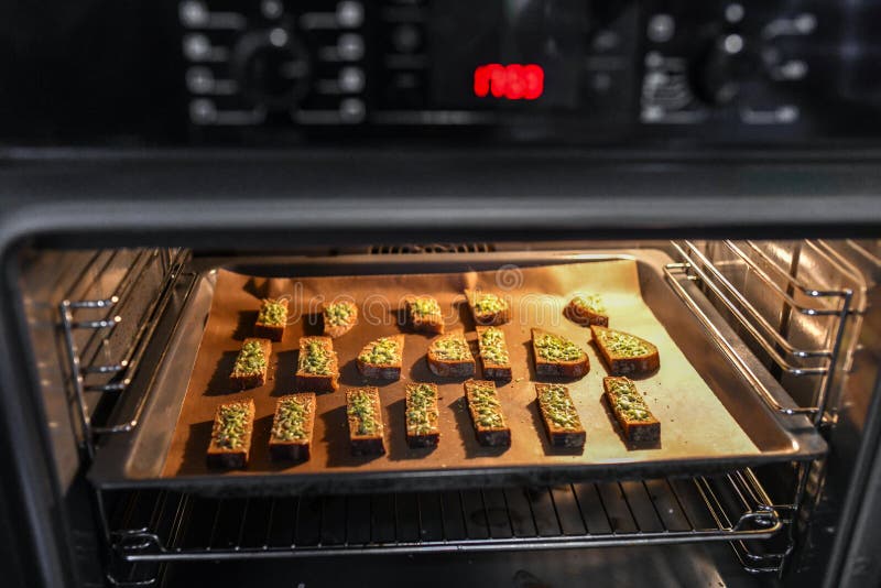 Black bread with cheese in the oven. Roasted bread with cheese and spices, cooked in the oven on a black tray, delicious breakfast stock photography Black bread with cheese in the oven. Roasted bread with cheese and spices, cooked in the oven on a black tray, delicious breakfast stock photography