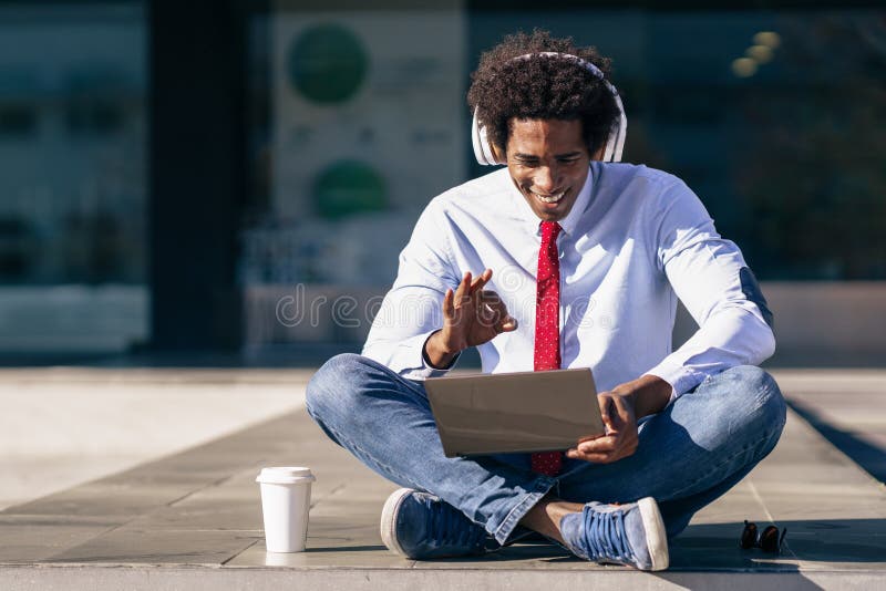 Black Businessman using laptop computer and headphones