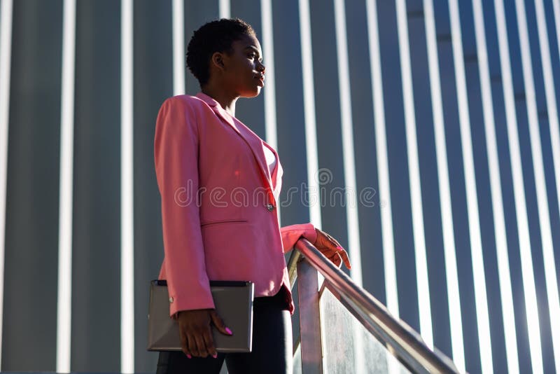 Black businesswoman standing near business office building.
