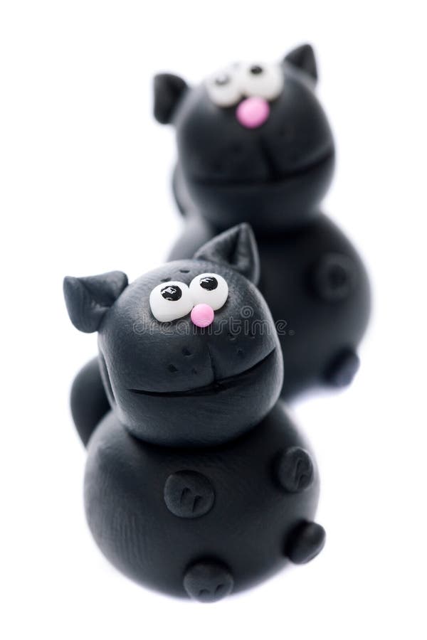 Black cats made of polymer clay isolated on white background