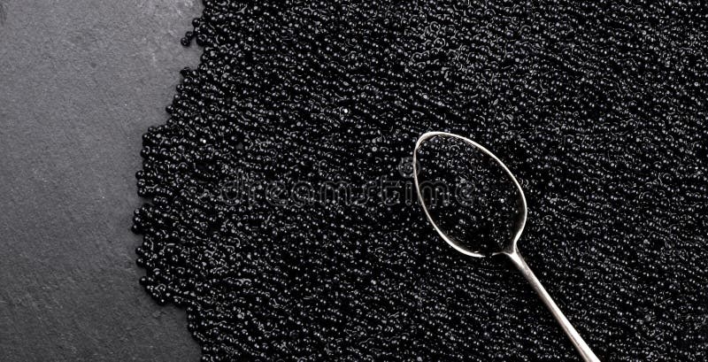 Black Caviar in golden spoon. High quality natural sturgeon black caviar close-up. Delicatessen