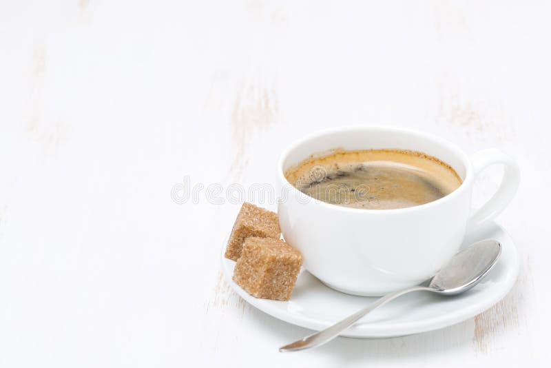 Black coffee with sugar on white wooden table and space for text