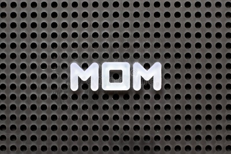Black color pegboard with white letter in word mom