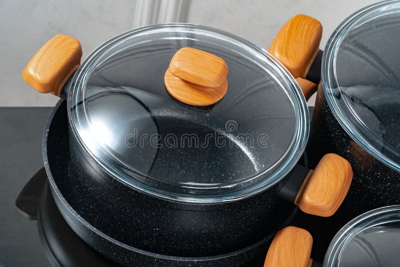 Black Cookware on Induction Stove Against Grey Wall Stock Image Image
