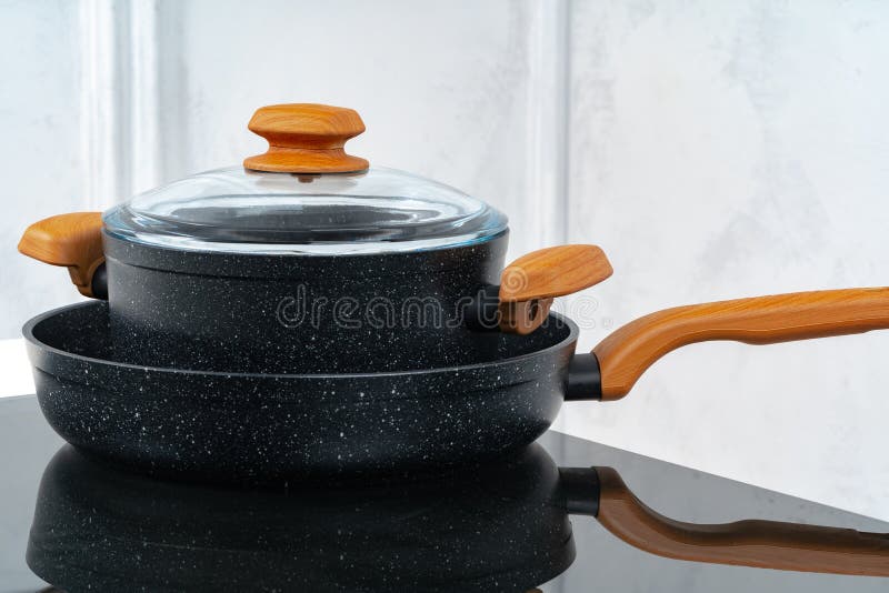 Black Cookware on Induction Stove Against Grey Wall Stock Image Image