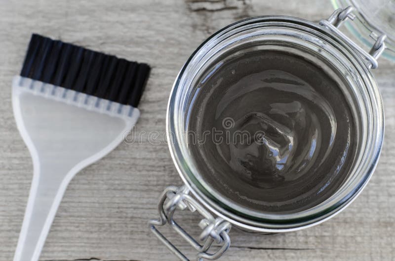 Black cosmetic volcanic clay in a glass jar