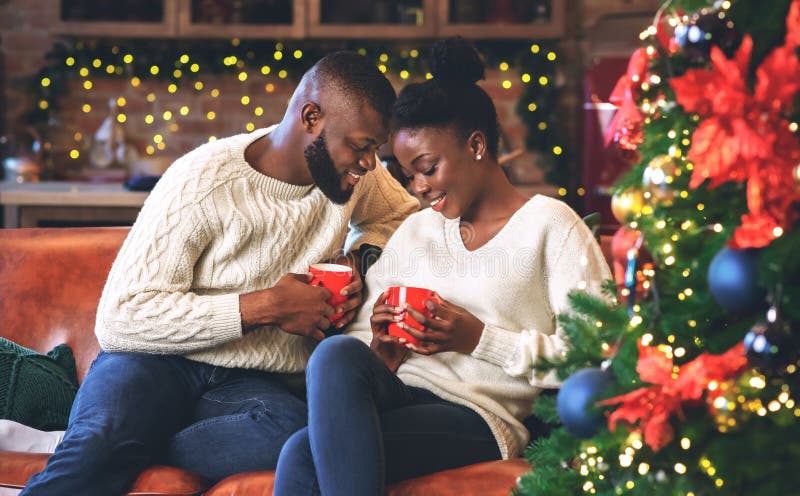 Black couple celebrating Christmas together, reading coffee grounds for fun stock photos