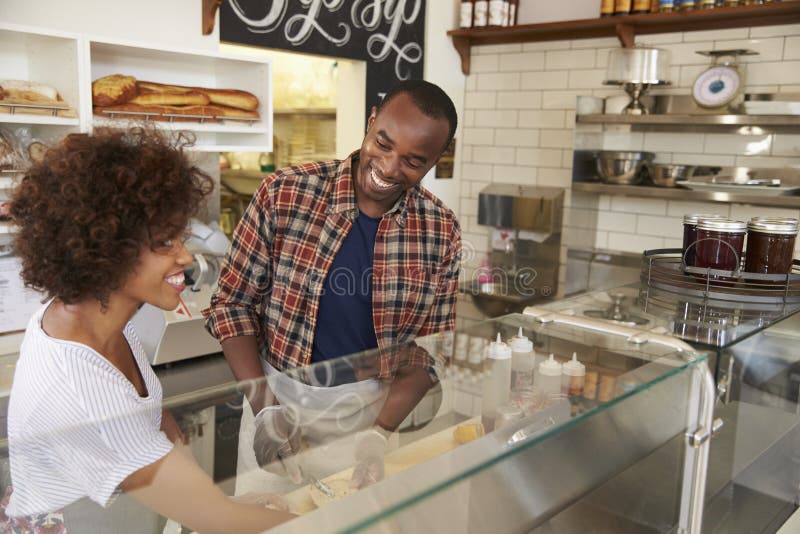 Black couple working behind the counter at a sandwich bar stock photos